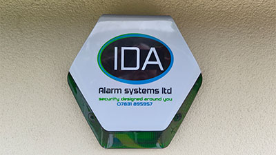 Hexagonal sign for IDA Alarm Systems Ltd featuring the tagline 