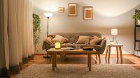 cozy living room with a gray sofa, wooden coffee table, and decorative lamps, featuring soft lighting and modern decor elements